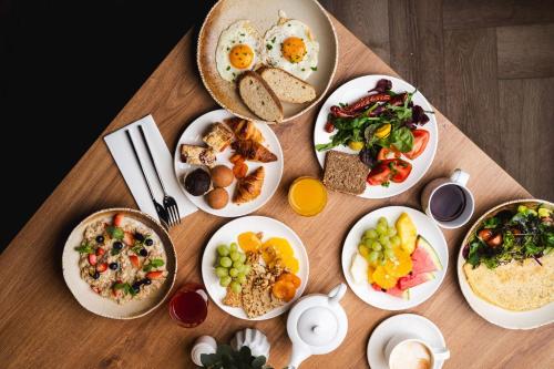a table with plates of breakfast foods on it at Focus Hotel Premium Olsztyn in Olsztyn