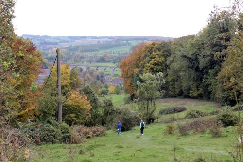 two people walking down a hill in a field at Hostel De Veurs in Sint-Martens-Voeren