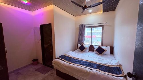 a bedroom with a bed with a ceiling fan and a window at HoTEL DARBAR PALACE in Dewās