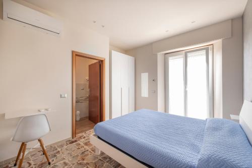 a bedroom with a blue bed and a window at Alba sul Mare Guest House in Massignano