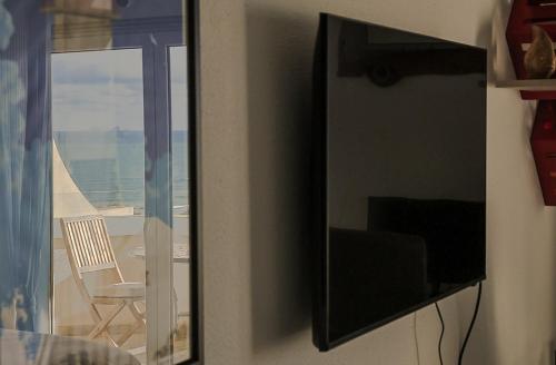 a mirror hanging on a wall with a view of the ocean at BBA Appartement climatisé vue mer Baleal in Ferrel