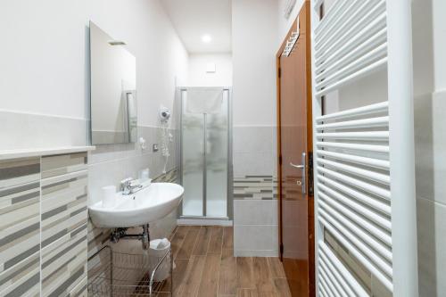 a white bathroom with a sink and a shower at Alba sul Mare Guest House in Massignano