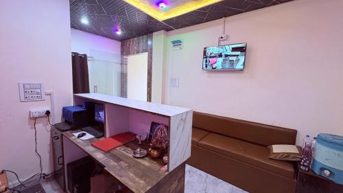 a room with a couch and a desk with a computer at HoTEL DARBAR PALACE in Dewās