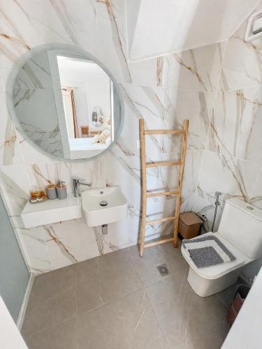 ein Badezimmer mit Waschbecken, Spiegel und Toilette in der Unterkunft ILIOLOUSTA in Kyparíssion
