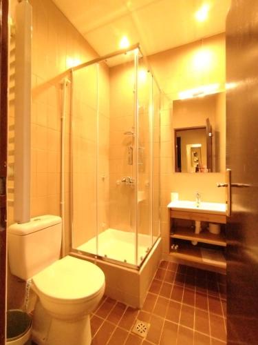 a bathroom with a shower and a toilet and a sink at Hotel Vojvodina in Novi Sad