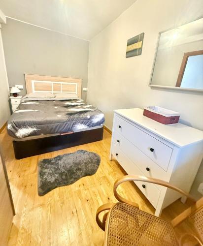 a bedroom with a bed and a dresser and a mirror at Casita Loredo in Mieres
