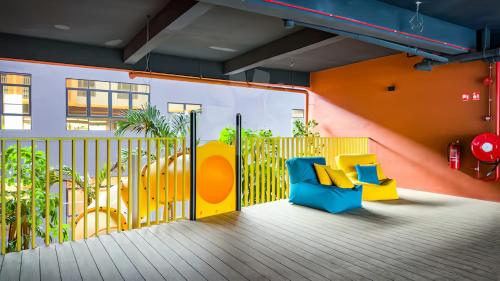a balcony with a blue and yellow chair at Piccadilly Service Residence Greentown Ipoh in Ipoh