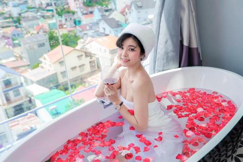 a woman in a bath tub filled with red hearts at TTR Skypool View Hotel - Đà lạt in Da Lat