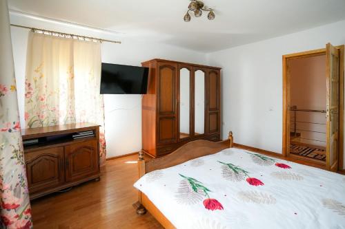 a bedroom with a bed and a flat screen tv at Casa RUXI in Jiblea Veche