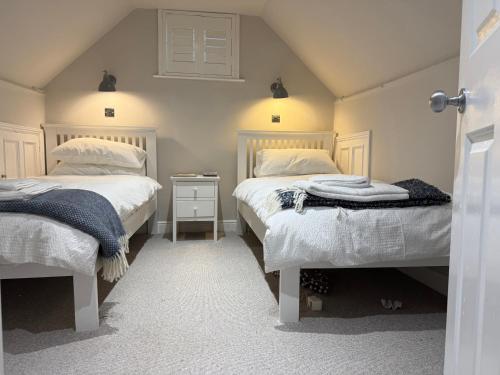 a bedroom with two beds and a nightstand between them at York Cottage in Southwold