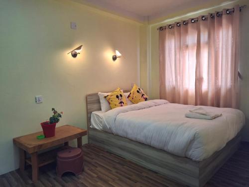 a bedroom with a large bed and a table at Mountain View Homestay in Tānsen