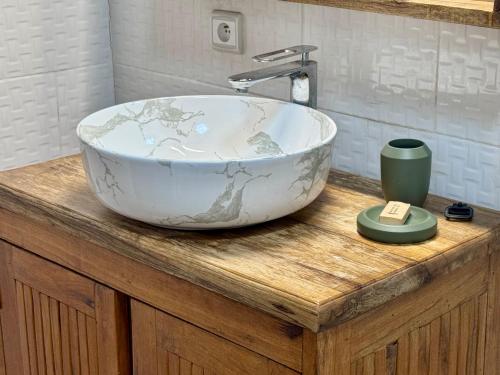 a bowl sink on a wooden counter in a bathroom at Le Jardin du Saloum in Toubakouta