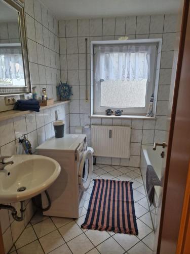 a bathroom with a sink and a toilet and a window at Ferienwohnung Unterneukirchen mit Garten-Terrasse in Unterneukirchen