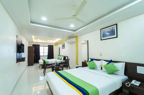 a hotel room with a bed and a table at Kaizen Stays And Resto in Panchgani