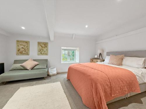 a bedroom with a large bed and a couch at Vine Cottage in Thornham