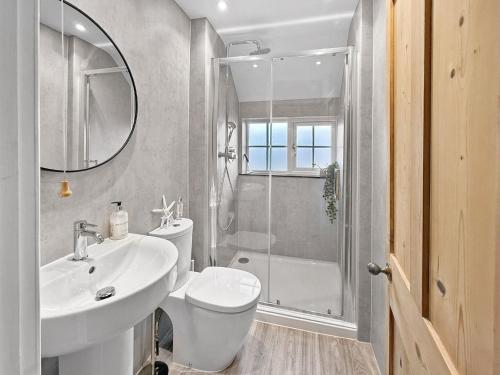 a bathroom with a toilet and a sink and a shower at Vine Cottage in Thornham