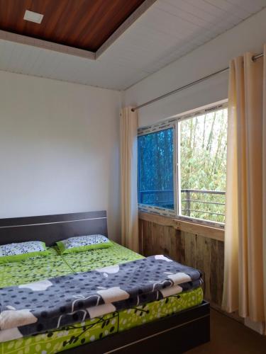 a bedroom with a bed and a window at Ribhoi Jungle in Khānāpāra
