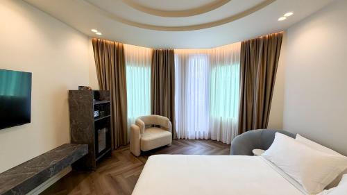 a hotel room with a bed and a tv at Vatër Selected Rooms in Tirana
