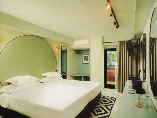 a bedroom with a large white bed and a mirror at Topazio Vibe Beach Hotel & Apartments - Adults Friendly in Albufeira