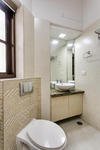 a bathroom with a toilet and a sink at Avanti Tenantry-Luxurious Service Apartments in New Delhi