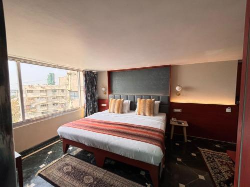 a hotel room with a bed and a window at Hiltop Hotel in Mumbai