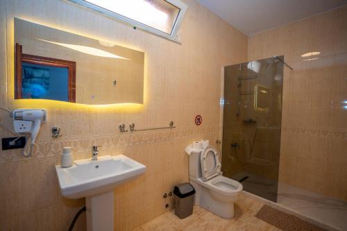 a bathroom with a sink and a toilet and a shower at Hotel Pepe in Shkodër