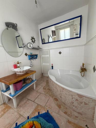 a bathroom with a tub and a sink and a mirror at Ferienwohnung Sieg in Mittelhof