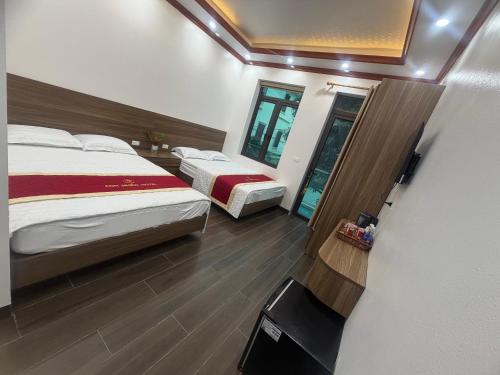a hotel room with two beds and a mirror at Anh Nhiên Hotel in Ninh Binh