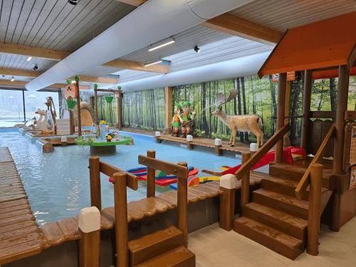 a room with a pool of water with animals in it at Vakantiepark Ommerland in Ommen