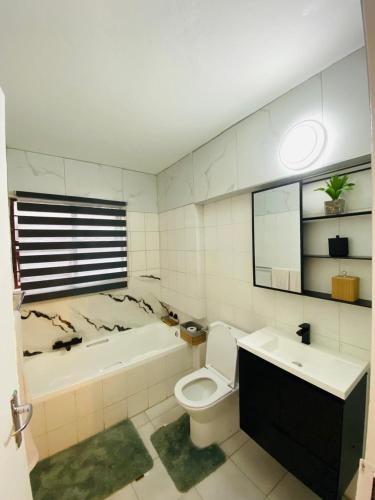 a bathroom with a toilet and a tub and a sink at Villa Elizabeth - Fourways Gardens Sandton in Fourways