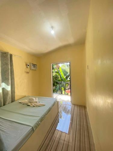 a small bedroom with a bed and a window at Villa Nicolasa in Siquijor