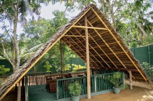 a bamboo roofed pavilion with potted plants at Villa Hatange in Weligama