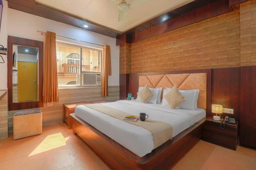 a bedroom with a large bed and a window at Hotel Kanha in Haridwār