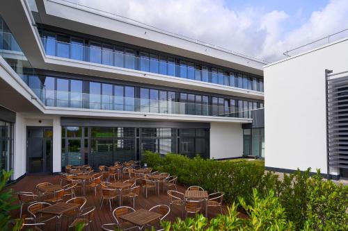 Eine Gruppe von Stühlen und Tischen vor einem Gebäude in der Unterkunft Hella Globe in Lippstadt