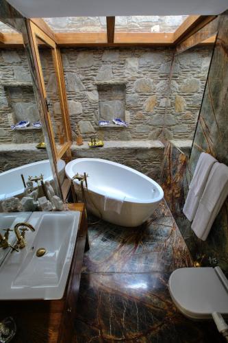 a large bathroom with a tub and a sink at Ibri Hotel in Selcuk