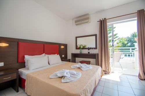 a hotel room with a bed with towels on it at Premium ikaros in Laganas