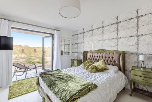 a bedroom with a bed and a large window at Washington Beach House with Lodge in Heacham