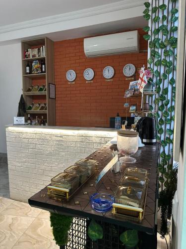 a counter in a kitchen with clocks on a wall at Tbil Inn Hotel in Tbilisi City
