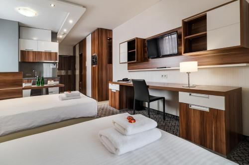 a hotel room with two beds and a desk at Aparthotel Vanilla in Krakow