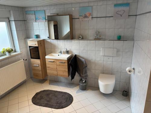 a bathroom with a sink and a toilet and a mirror at Ferienwohnung Lodge 13 in Ehrenberg