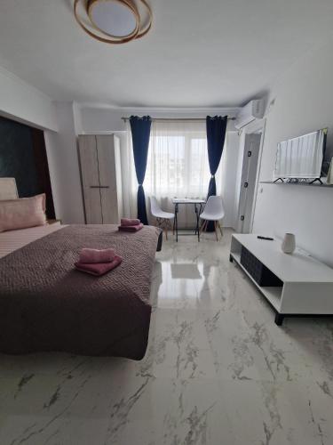 a bedroom with a large bed and a table at Little Escape in Brăila