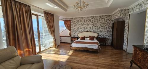 a bedroom with a bed and a couch and windows at Karmia Boutique in Piatra Neamţ