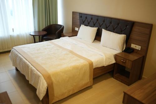 a bedroom with a large bed and a chair at Burgaz Resort Aquapark Hotel in Kırklareli
