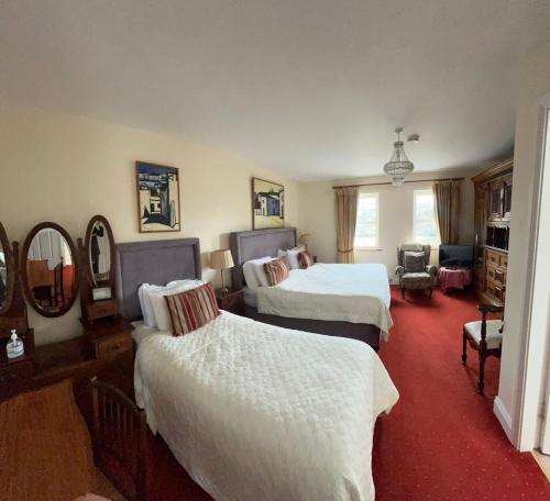 a hotel room with two beds and a mirror at Muxnaw Lodge in Kenmare