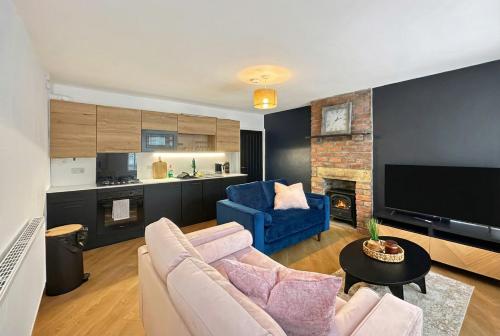a living room with a couch and a blue chair at Brontë Country 4 Bed Retreat with Fireplace in Oakworth