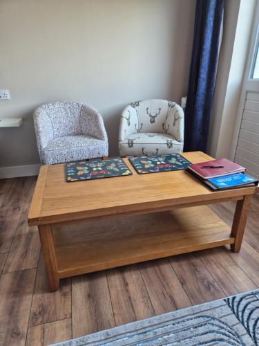 a coffee table with a chair and a book at taigh beag in Fort William