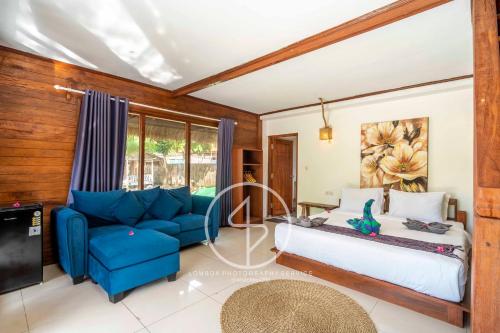 a bedroom with a bed and a blue couch at Ings Garden Acommodation in Gili Islands