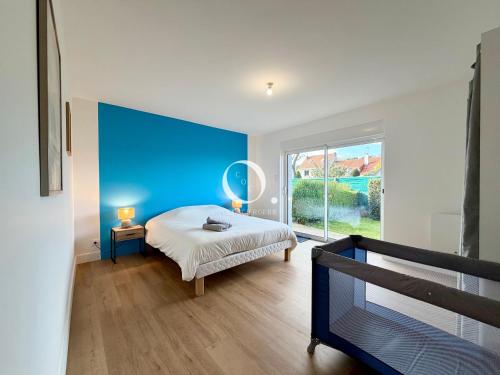 a bedroom with a bed and a blue wall at GC - La Voile Bleue in Wissant