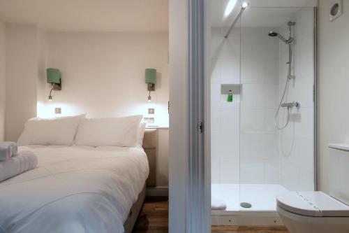 a bedroom with a shower and a bed and a bathroom at Finest Retreats - Alpine Cottage in Symonds Yat