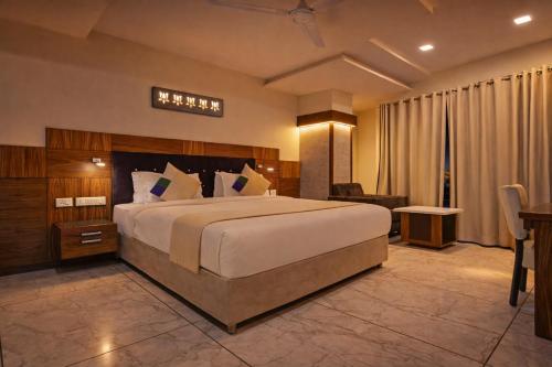 a hotel room with a large bed and a desk at Hotel Mandovin - A Premium Hotel In Udaipur in Udaipur